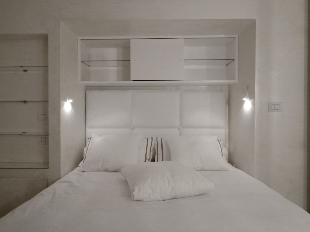 camera da letto total white con arredi su misura e applique a parete