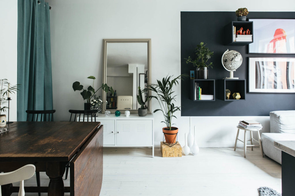 credenza bianca con specchio appoggiato sopra per organizzare una casa piccola