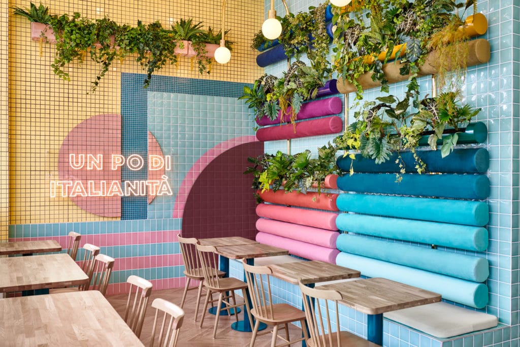 interno del ristorante Piada con dettaglio su tavoli e sedie in legno e panche azzurre e rosa