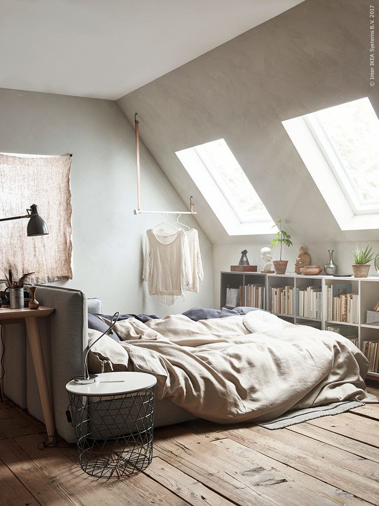 camera da letto con tetto spiovente e librerie sotto finestra