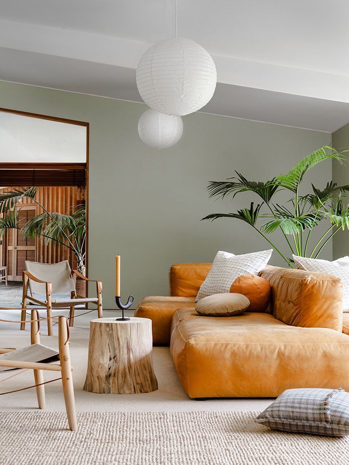 soggiorno con pareti verde chiaro e divano arancione 
