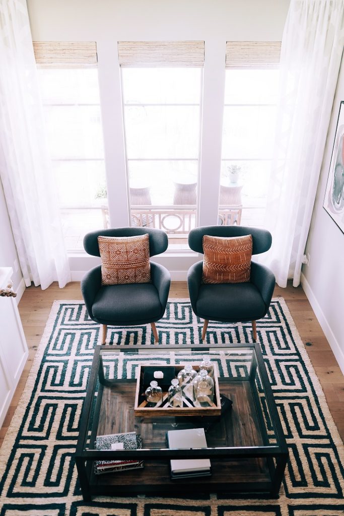 vista dall'alto di soggiorno moderno con tappeto bianco e nero, tavolo in vetro e poltrone nere
