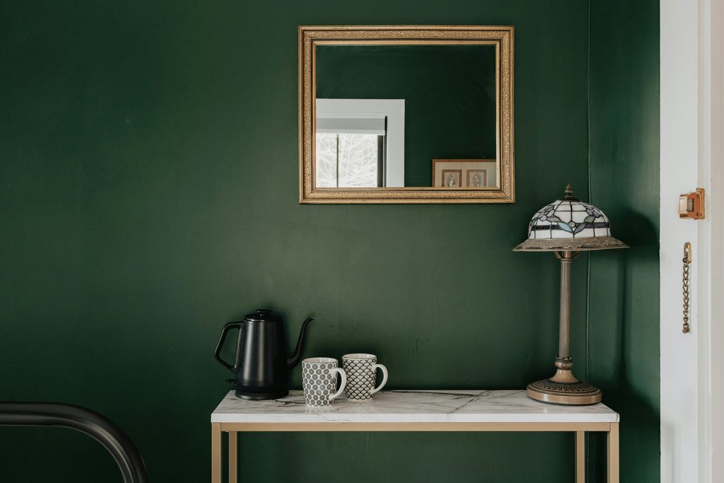 Palette e ambientazione con verde petrolio e viola per un arredamento di carattere