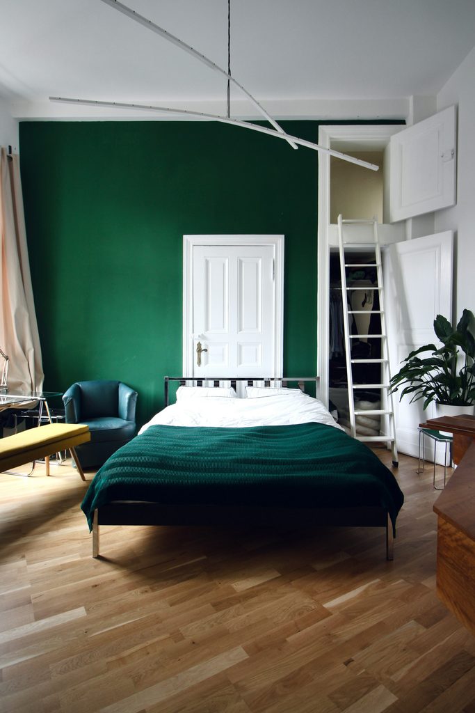 Palette e ambientazione con verde petrolio e viola per un arredamento di carattere