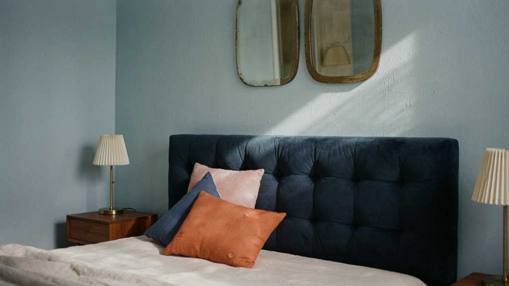 Camera da letto con parete blu avio, letto e arredi in stile contemporaneo vintage.