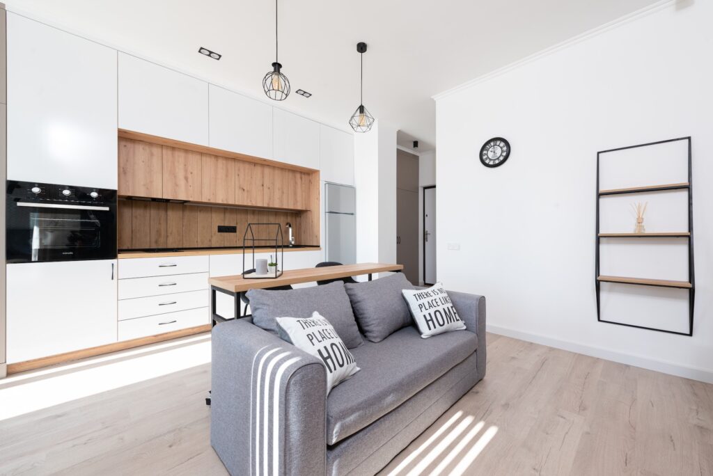 top cucina in legno massello di rovere con basi e pensili bianco opaco e divano in tessuto grigio