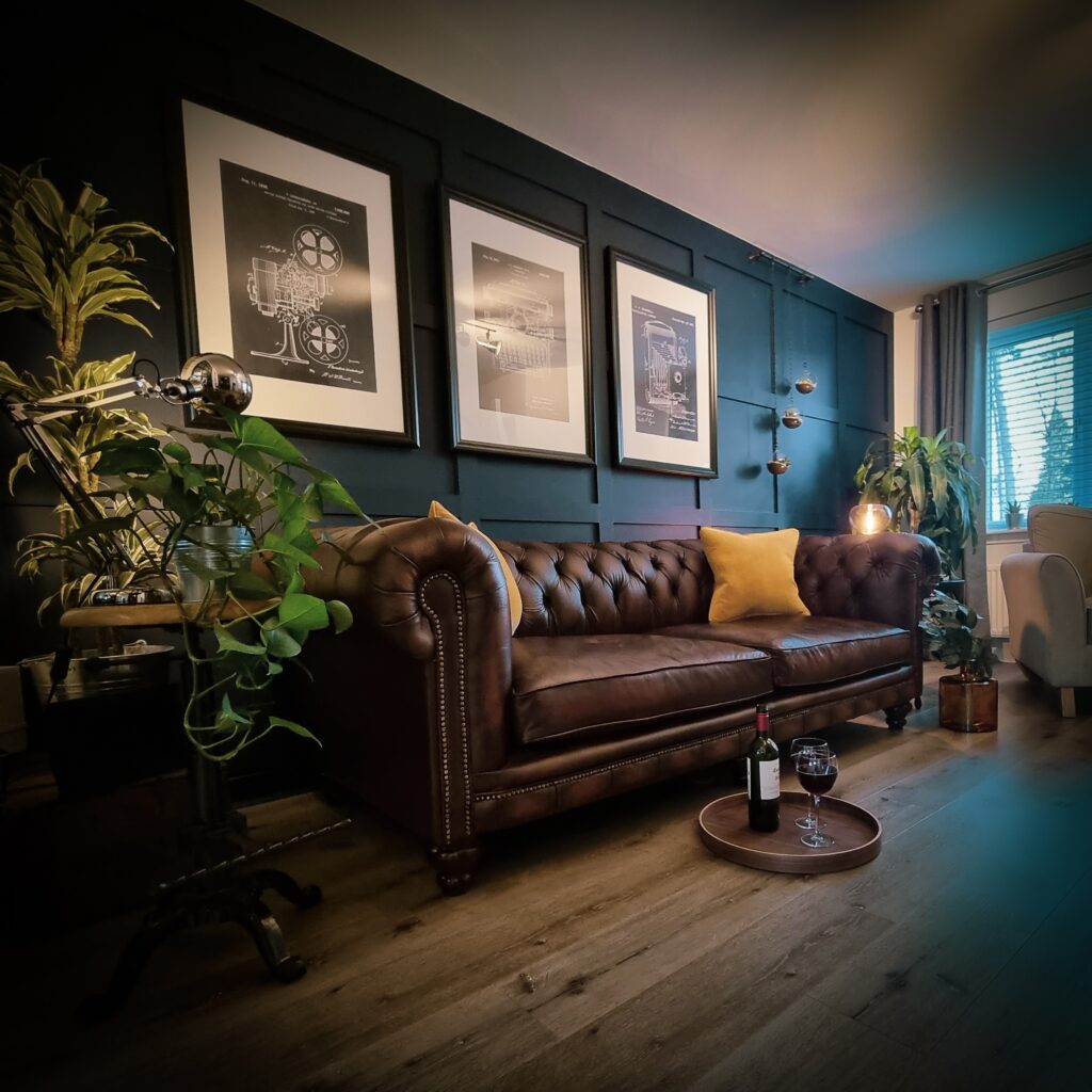 soggiorno in stile eclettico con cuoio marrone e parete boiserie blu petrolio